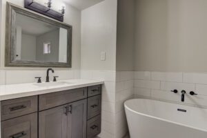 A bathroom with a sink, mirror and tub.