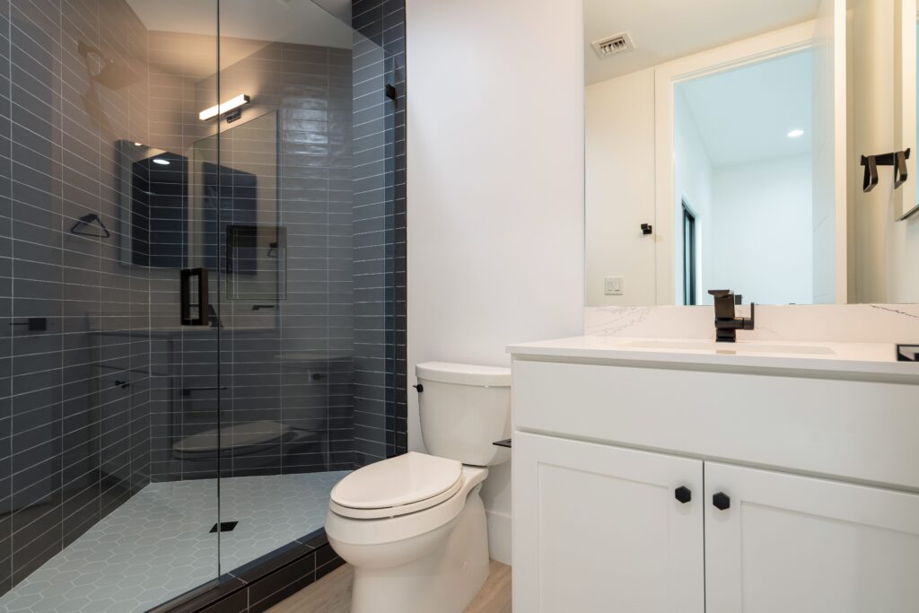 A bathroom with a toilet, sink and shower.