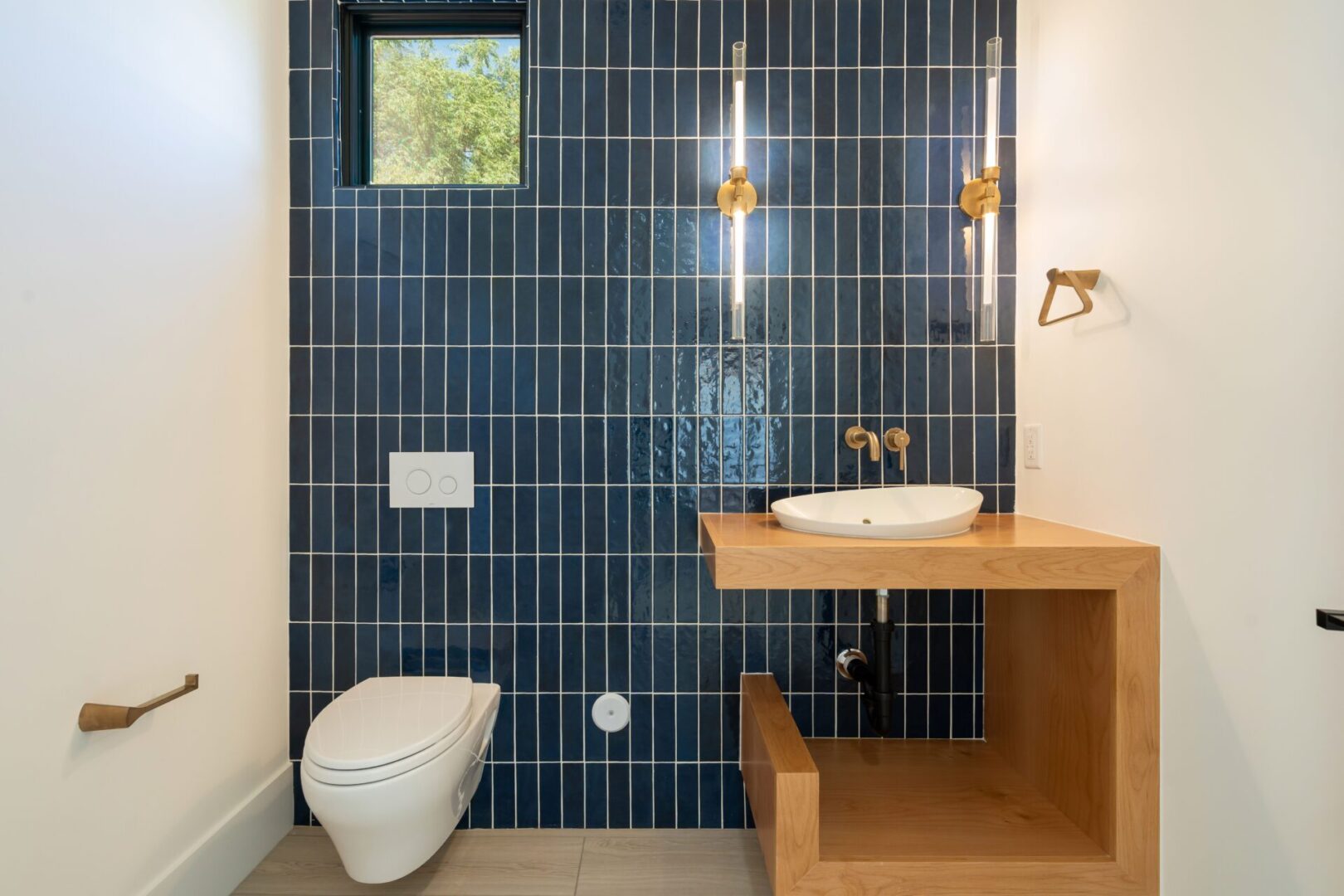 Unique bathroom vanity with modern styling and stacked vertical blue subway tile outlined in white grout accenting geometric lines.