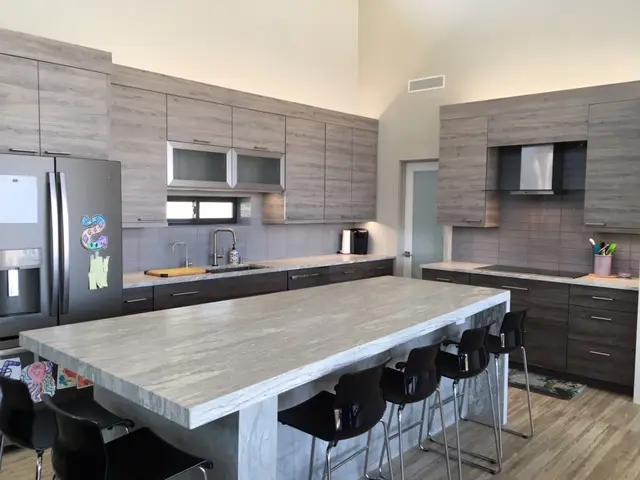 A large kitchen with a big table and lots of cabinets