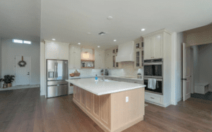 A inset kitchen with white cabinets and wood floors.