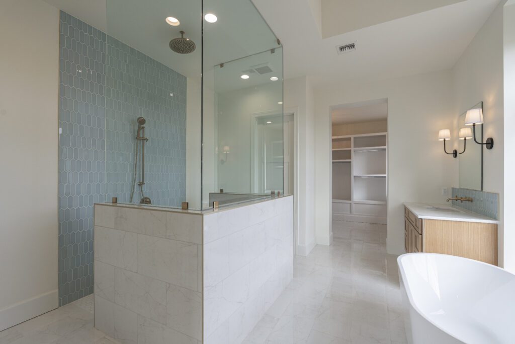 A bathroom with a walk in shower and tiled walls.

