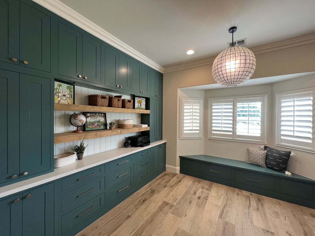 A room with green cabinets and wooden floors.