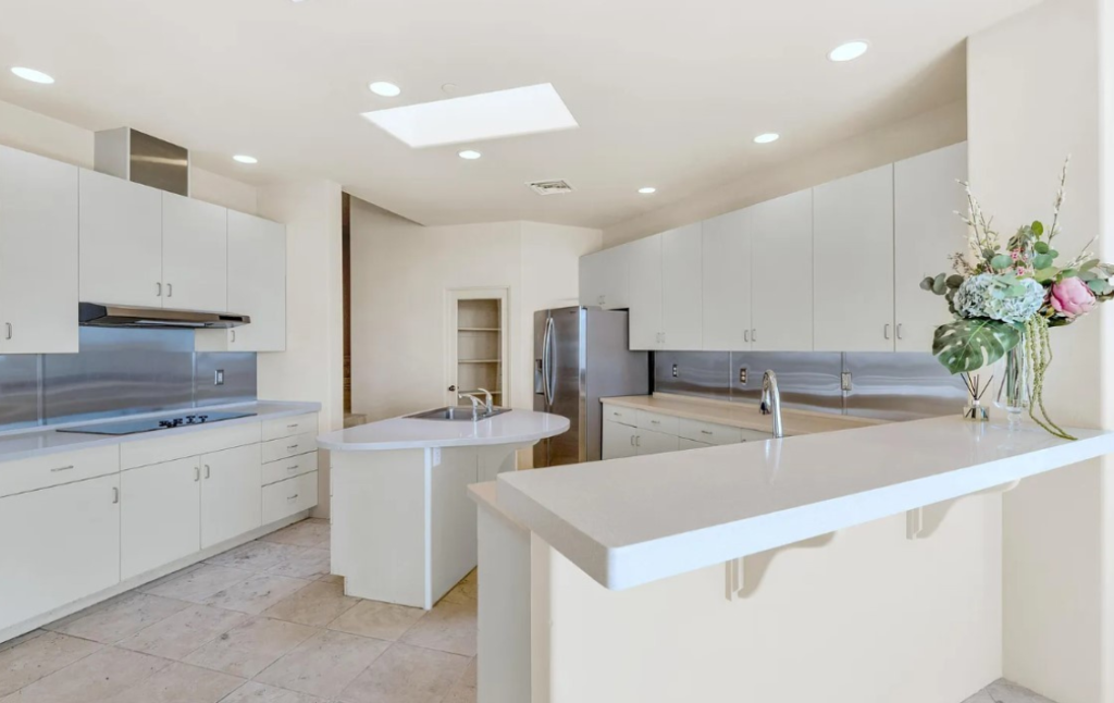 A kitchen with white cabinets and counters in it
