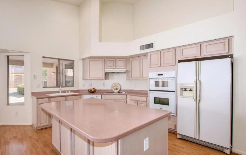 A large kitchen with an island and white appliances.