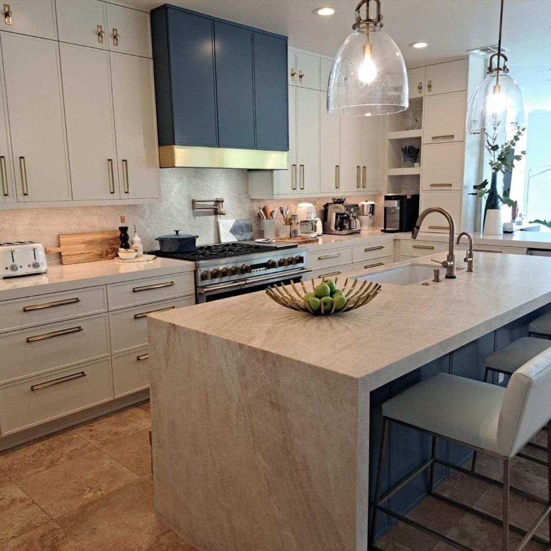 A kitchen with white cabinets and a large island.