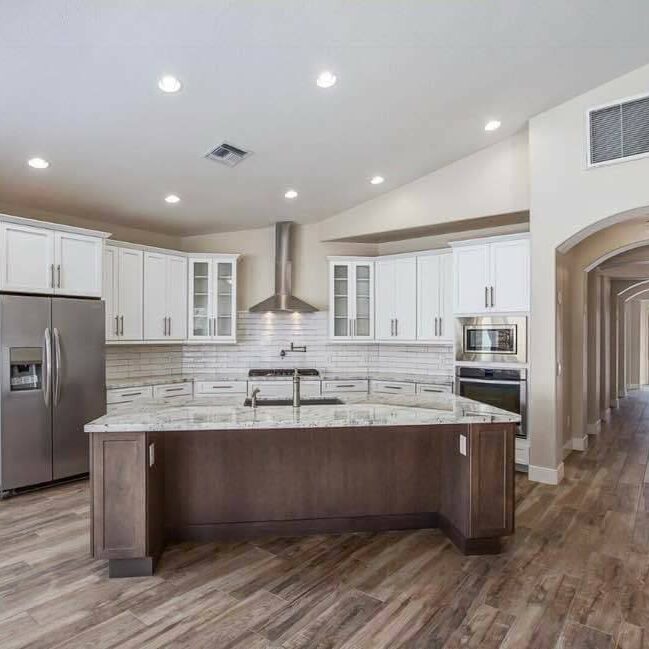 A kitchen with an island and stainless steel appliances.