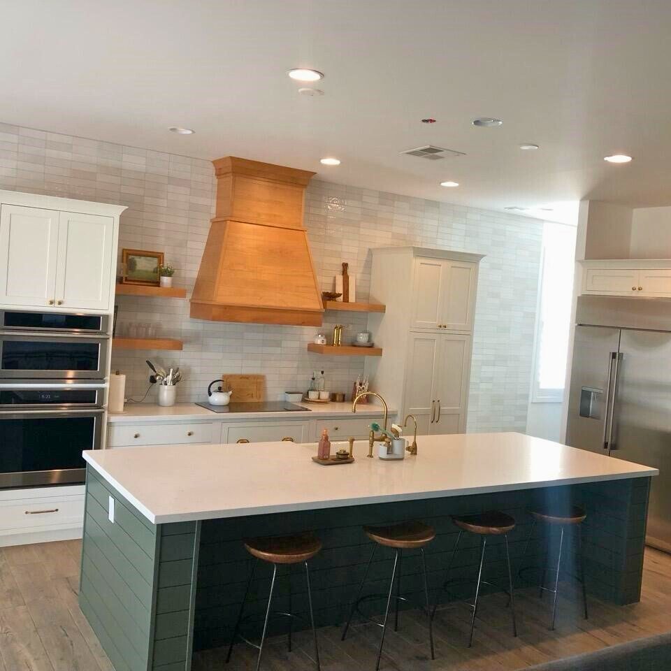 A kitchen with an island and white cabinets