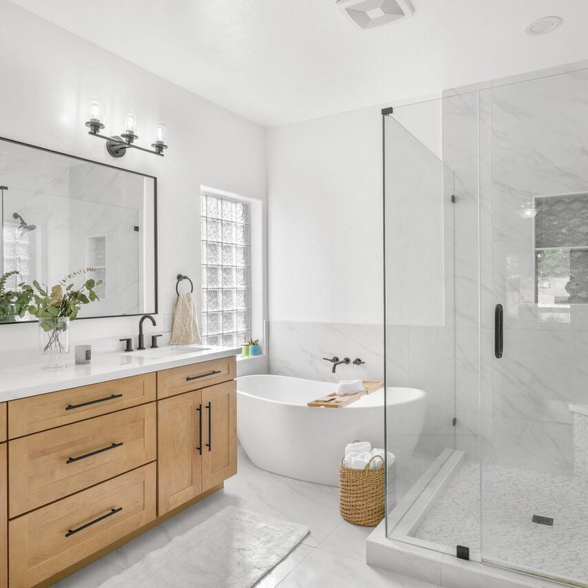 A bathroom with a tub, sink and shower.