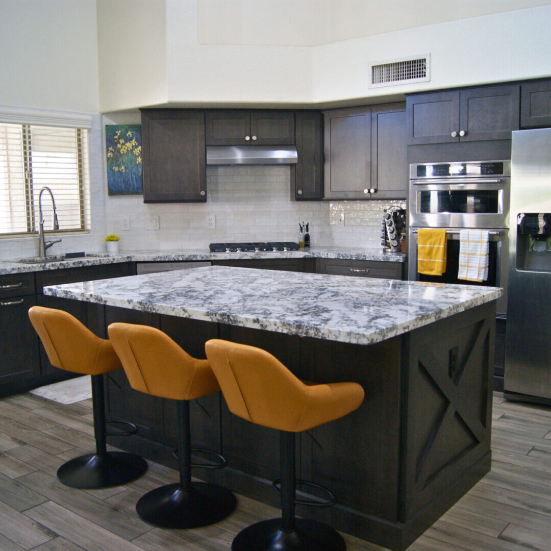 A kitchen with three chairs and an island