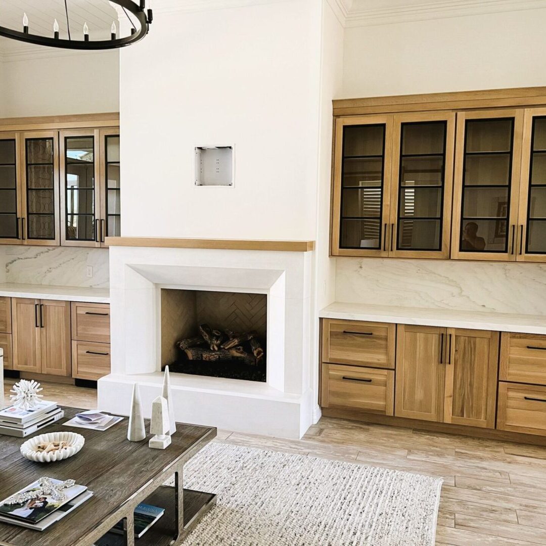 A living room with a fireplace and wooden cabinets