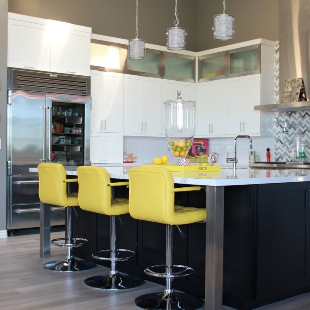 A kitchen with yellow chairs and white cabinets