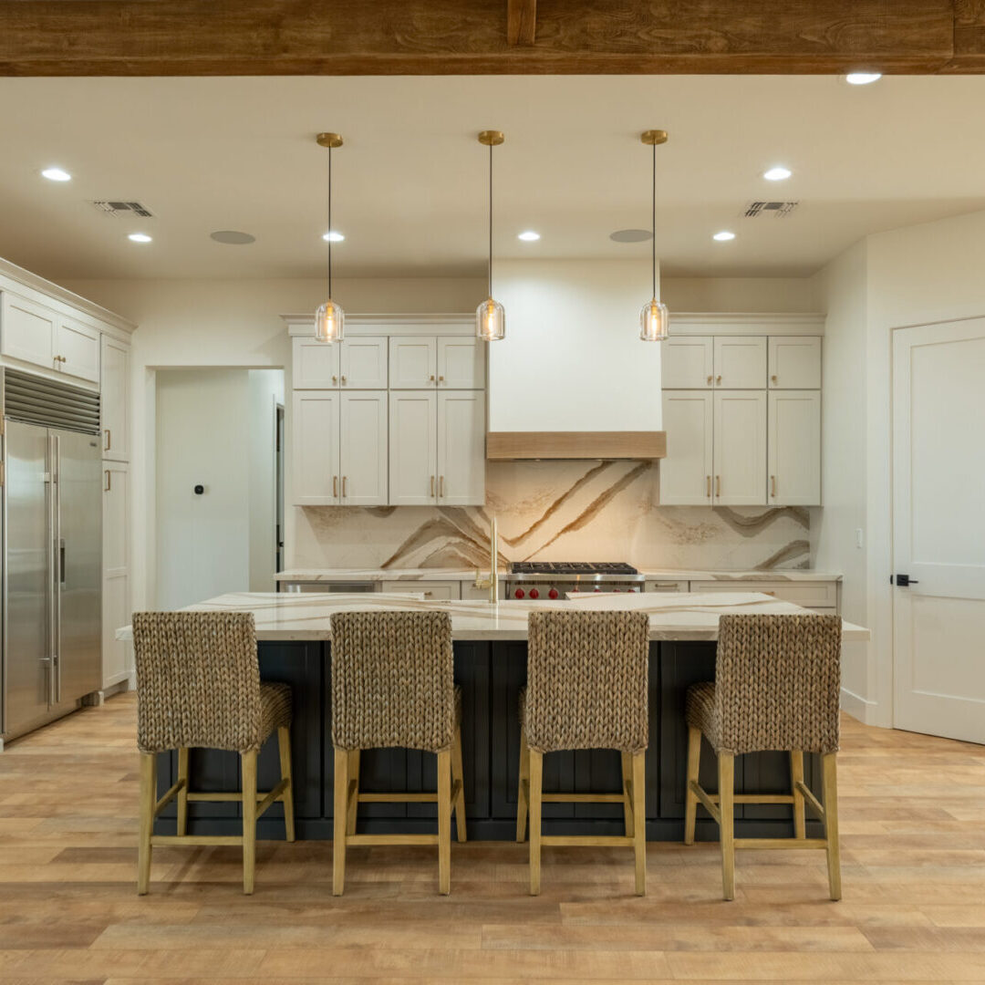 A kitchen with light gray and dark gray shaker cabinets and a quartz countertop