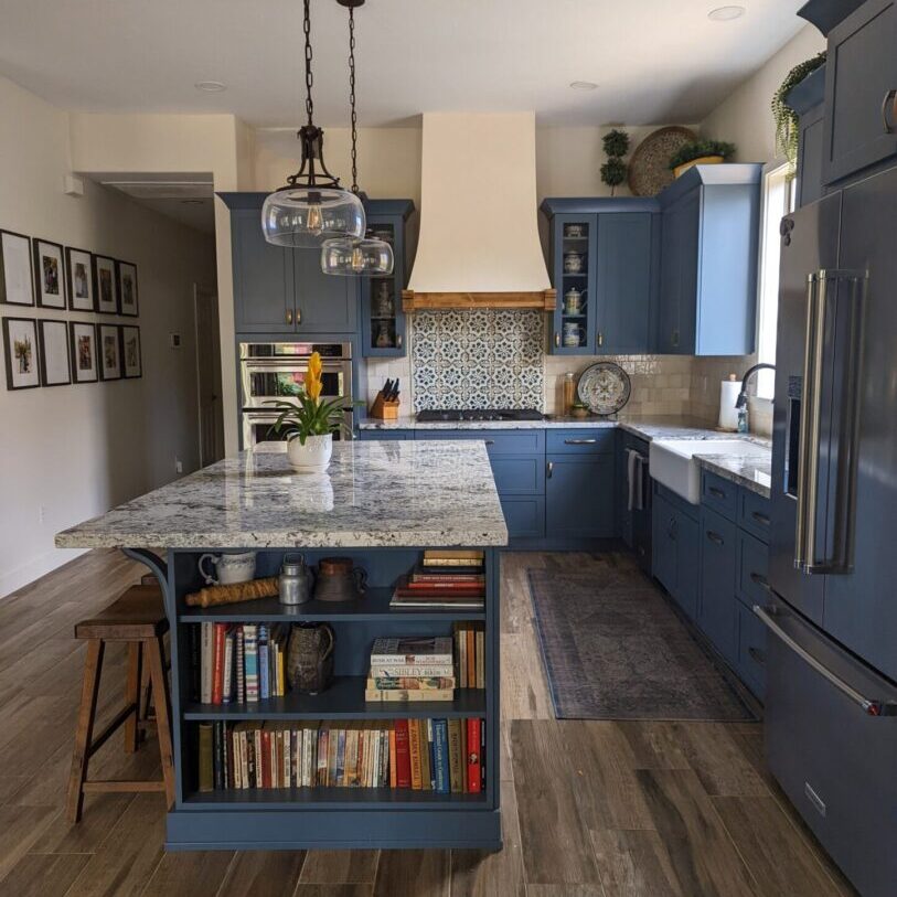 A kitchen with blue cabinets and wooden floors.