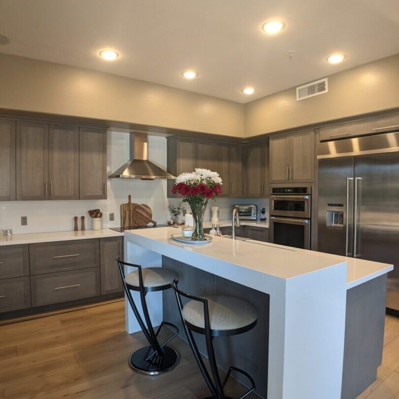 A kitchen with an island and stainless steel appliances.